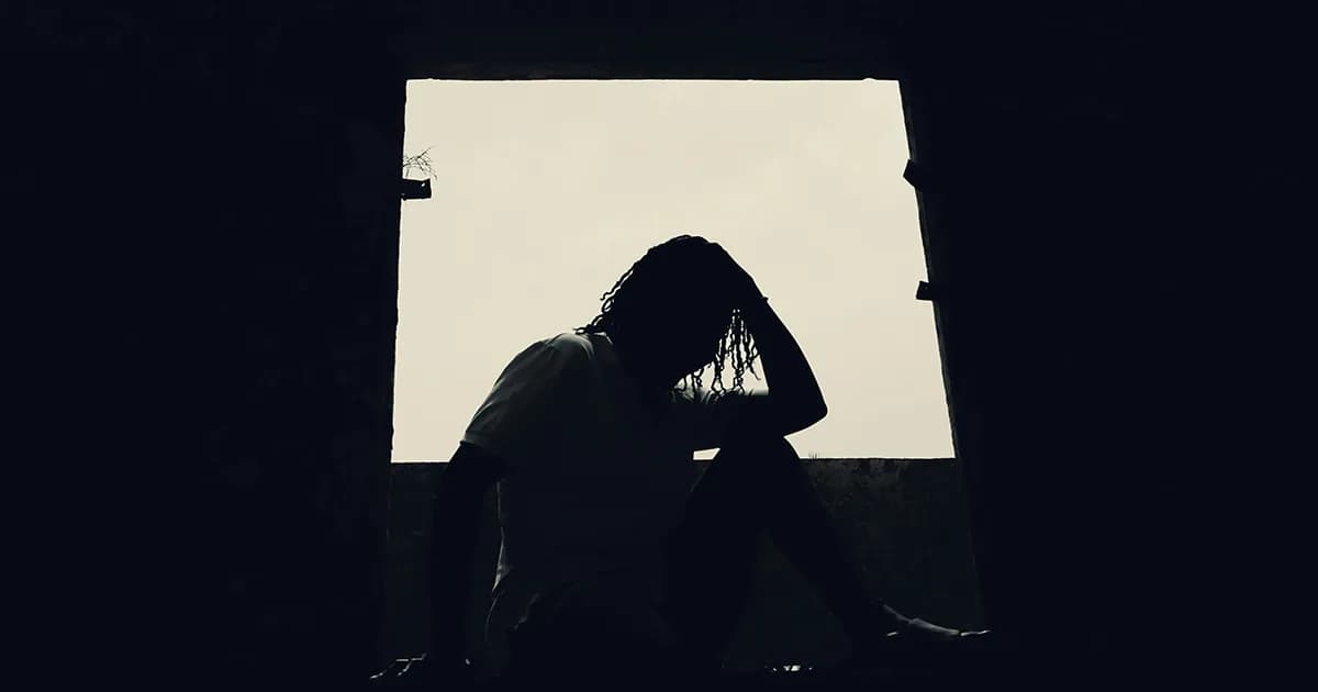 Silueta de una persona en penumbra contemplando la luz exterior, simbolizando la búsqueda de claridad mental cuando no sabes qué hacer con tu vida.