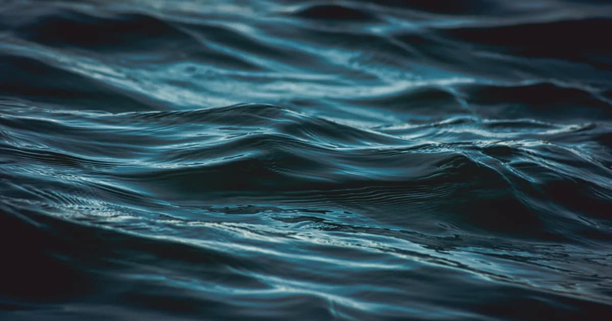 Superficie del agua con olas suaves en tonos oscuros, metáfora del flujo de los pensamientos y la búsqueda de paz interior.